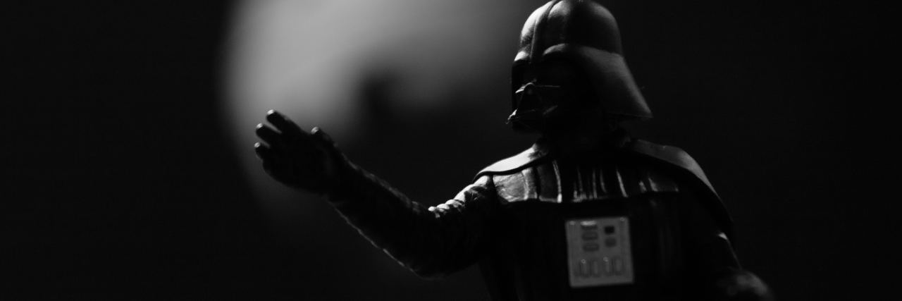 black and white photo of toy Darth Vader from Star Wars with hand outstretched in force grip