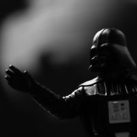 black and white photo of toy Darth Vader from Star Wars with hand outstretched in force grip