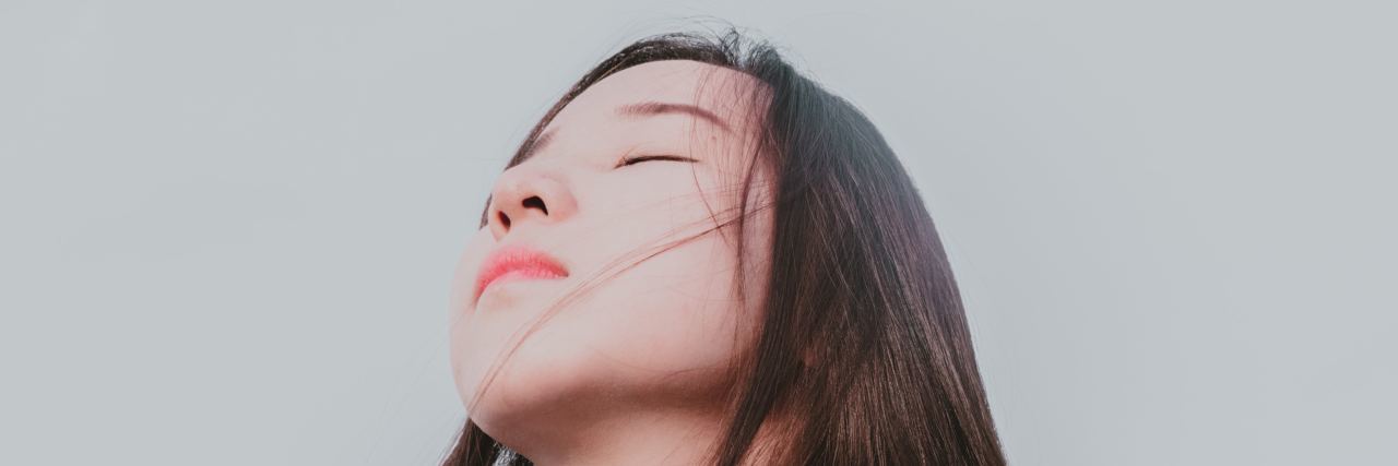 Feeling 'Less Than' While Living With a Chronic Illness woman with eyes closed and head tilted