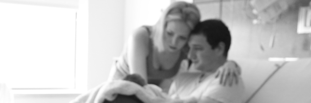 Heartbreak, Healing and Hope After Losing My Baby With Down Syndrome Parents in a hospital room with their newborn baby.