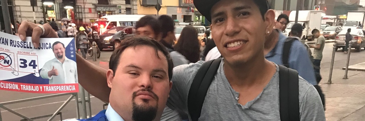 Peru's Bryan Russell First Person With Down Syndrome to Run for Office Bryan Russell stands next to a man on a bike holding a campaign sign and button