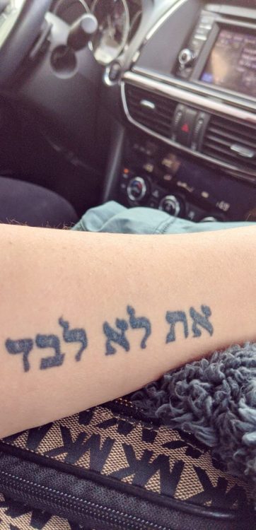 Hebrew phrase tattoo meaning "you are not alone."