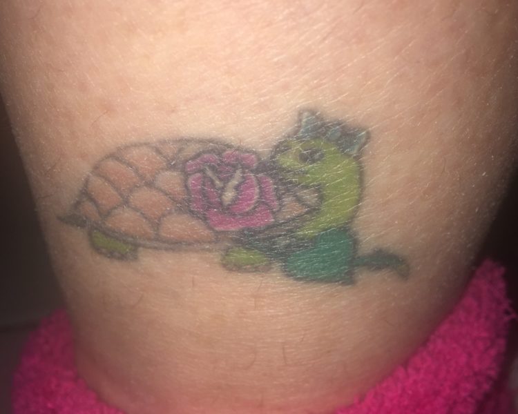 Tattoo of a turtle with a rose on the shell