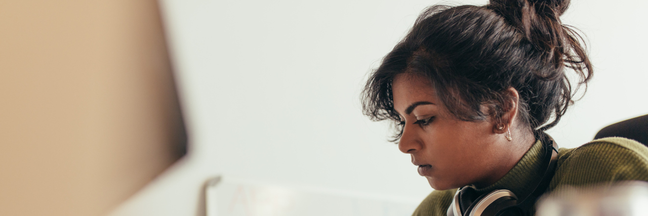 Why Is Mental Health Stigmatized in South Asian Communities? A photo of a South Asian woman sitting at her desk.