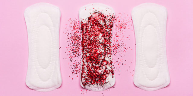 Why I Actually Miss Getting My Period Three pads in a row. The middle one is covered in red glitter, representing period blood