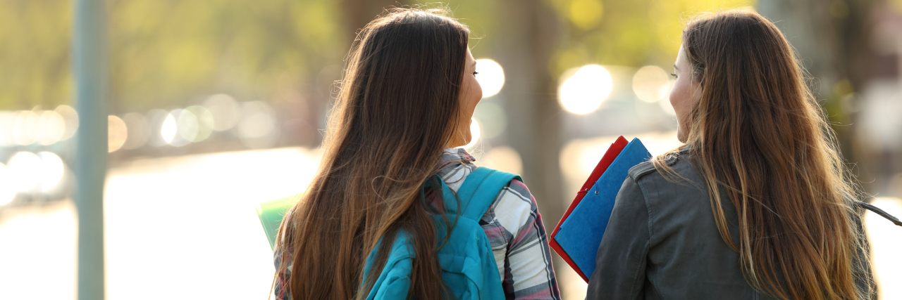 The Truth About Autism: Autism Facts and Debunked Myths Back view of two happy students walking and talking in a university campus