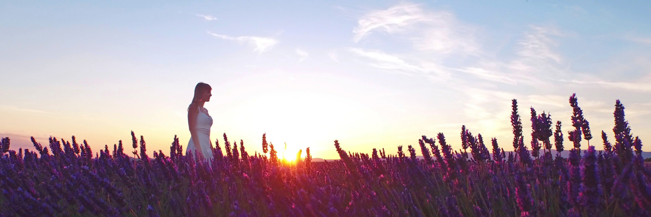 Accepting Myself as a Person With Chronic Pain Woman in white dress walking through lavender fields. Sunrise in Provence, France