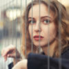 young woman behind bars looking at the camera