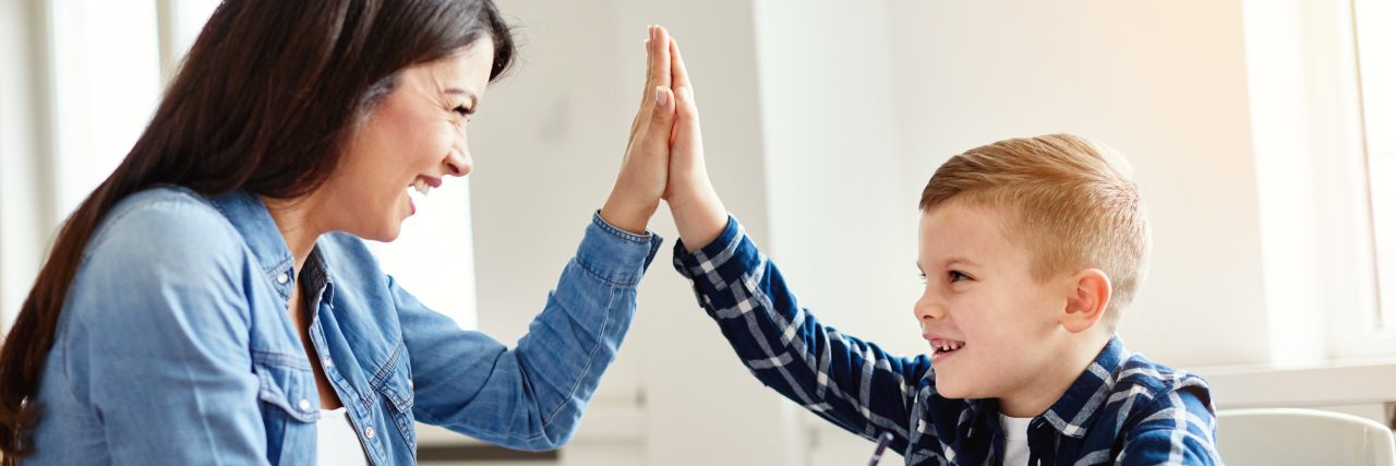 Determining Your Child with Autism's Love Language a woman is giving a high-five to a little boy