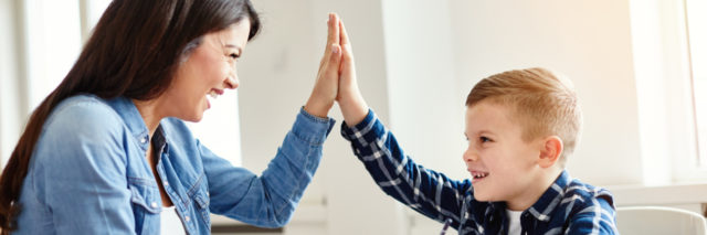 a woman is giving a high-five to a little boy