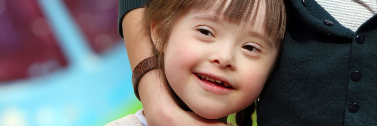 Mother hugging her daughter with Down syndrome.