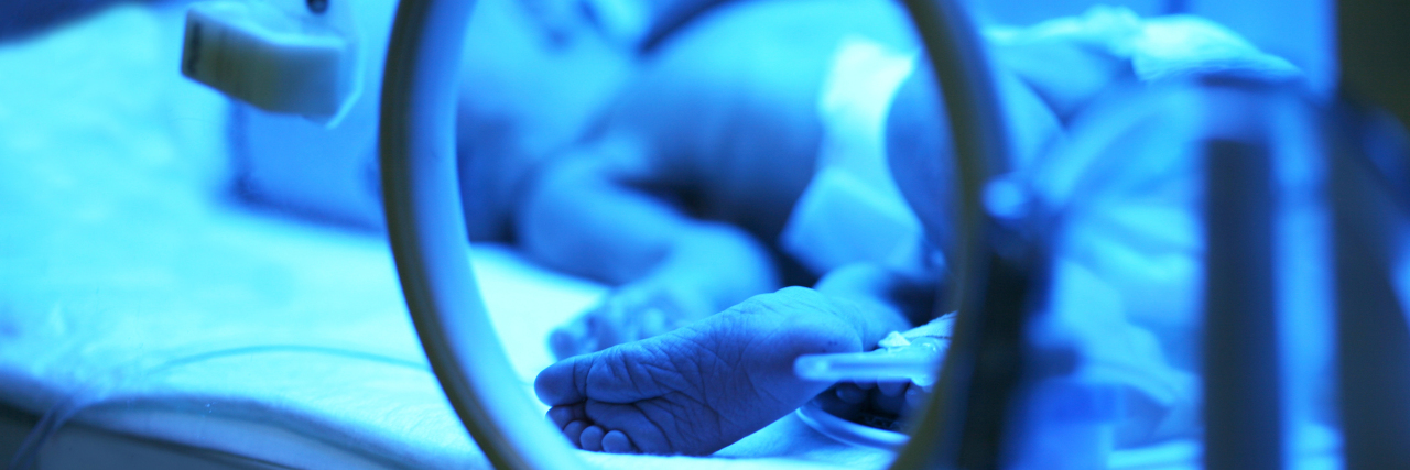 a baby in a NICU incubator