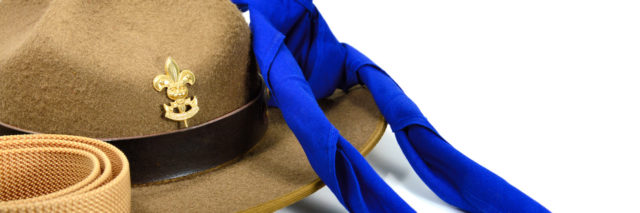 brown brim hat (hat of scout) isolated on white while blue neck time and beige belt