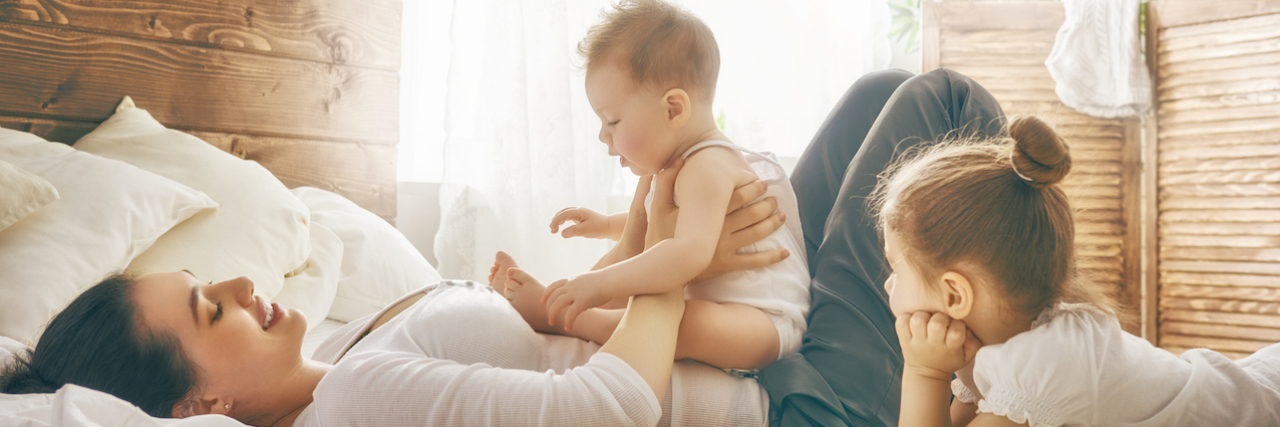 The Ups and Downs of Parenting With Bipolar Disorder Mother and her young daughters playing at home