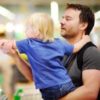 a dad grocery shopping with his toddler son