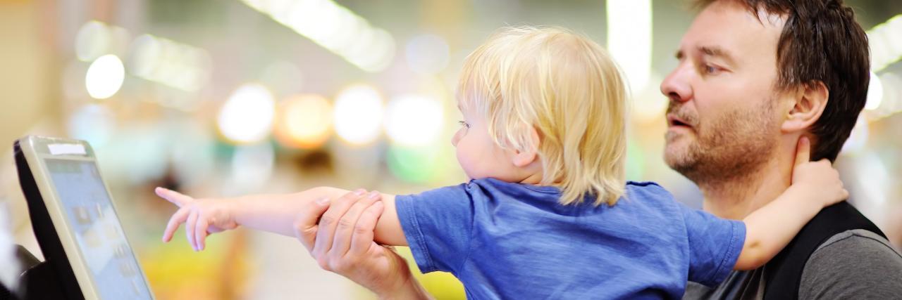 Stop Complimenting My Husband for Being a Parent a dad grocery shopping with his toddler son