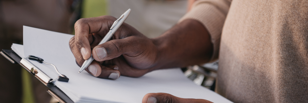 Does Modifying a Hospital Contract Prevent Surprise Medical Bills? cropped view of african american man writing something on paper in clipboard