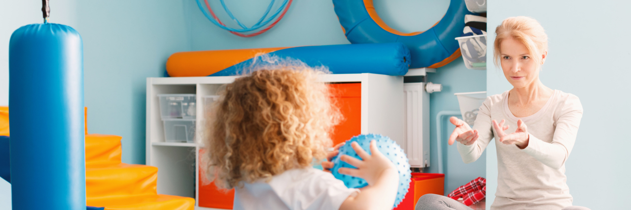 It's Time to End the Stigma Around Early Intervention Child playing with therapist using a ball.