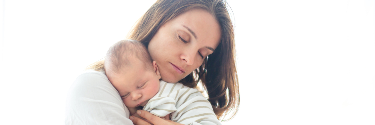 5 Triggers and Things I Learned as a Mom With Anxiety young mother holding her newborn baby with her eyes closed