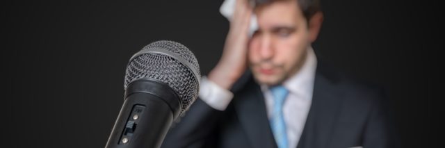 a microphone placed in front of a nervous man about to give a public speech