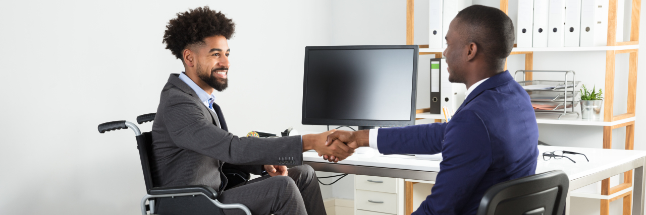 Job Gains for People With Disabilities Have Decreased Ten-fold Man in wheelchair shaking hands with interviewer.