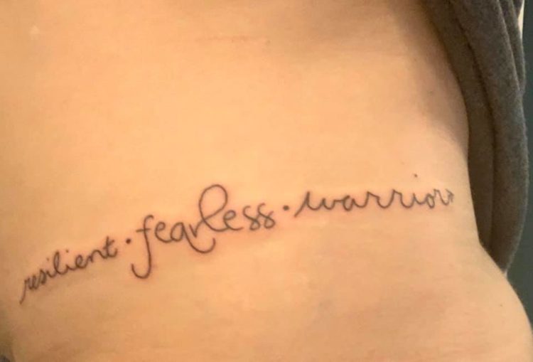 a tattoo that says "resilient. fearless. warrior."