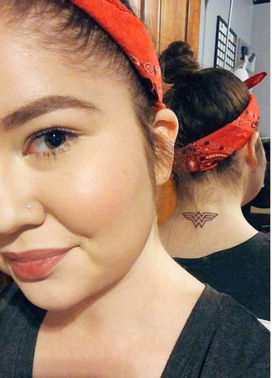 The author showing her tattoo of the Wonder Woman symbol on her neck