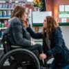 Actress Kiera Allen in her wheel chair while Sarah Paulson kneels in front of her, touching her face