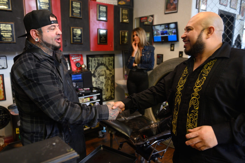 José Alvarado shakes hands with Eric Catalano after the fingernail tattoo procedure at Eternal Ink Tattoo Studio on Nov. 20, 2019, in Hecker, Ill. (Michael B. Thomas for KHN)