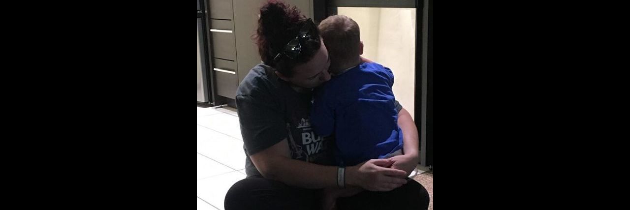 Why Parents of Children With Congenital Heart Defects Need Help Too A mother and son embracing while sitting on the floor.