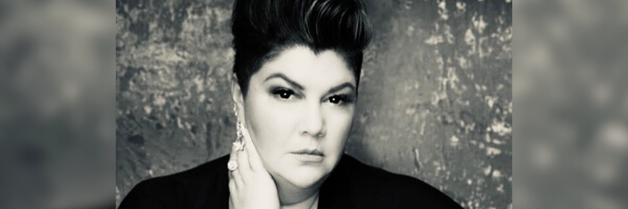 Why Reaching Out Is Important When Depression Leaves You Feeling Stuck black and white photo of author looking seriously into camera with her hand touching her neck