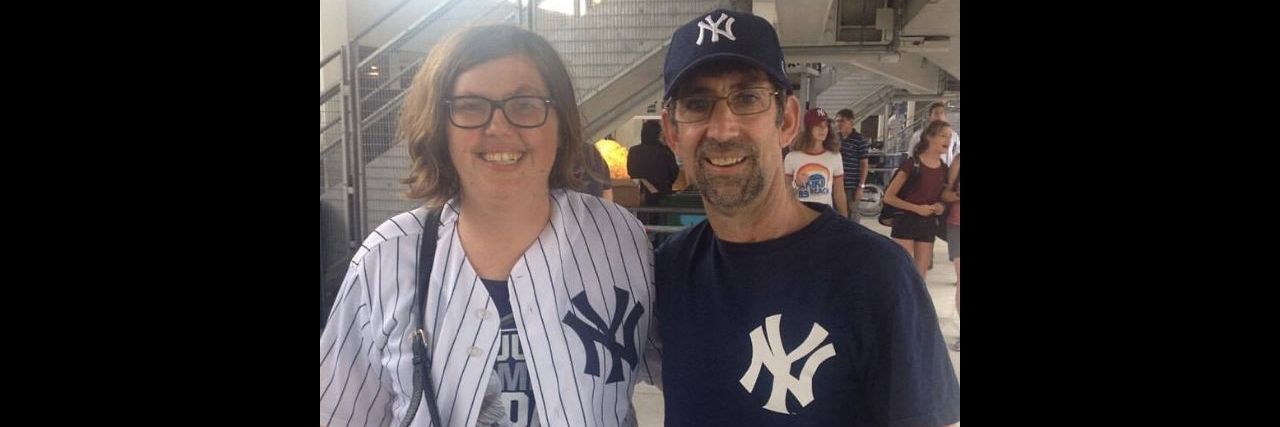 Pushing Through the Lonely Moments as an Athlete With a Disability a young woman and a man at a sporting event in Yankees gear posing for a picture