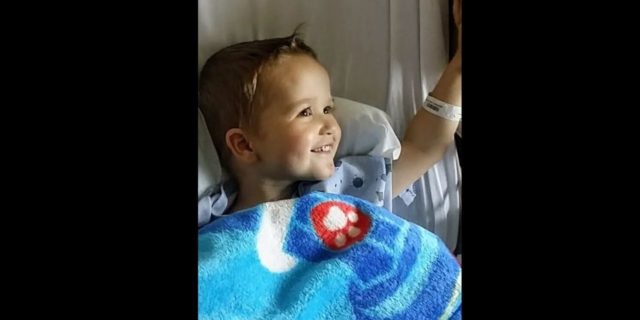 a baby boy in a hospital bed smiling