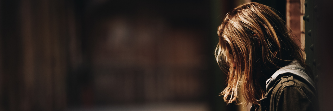 How Doctor-Delayed and Missed Diagnoses Harm Rare Disease Patients Sad woman with her face hidden behind her hair.