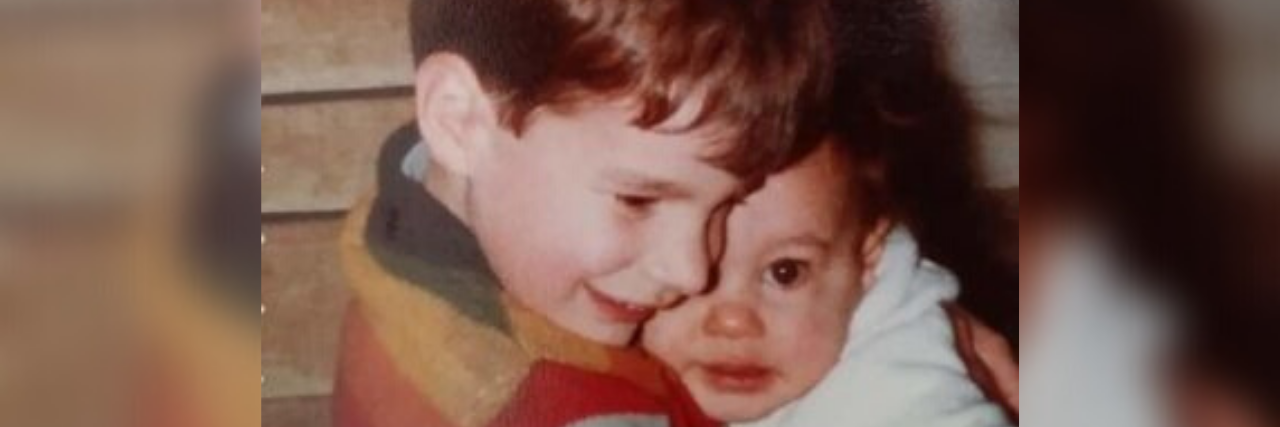 Grieving a Birthday When You Age Past a Loved One Who Died by Suicide photo of author's brother hugging her as a baby