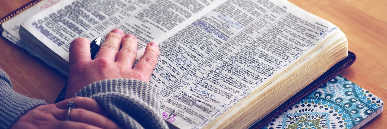 girl's hands on her bible reading