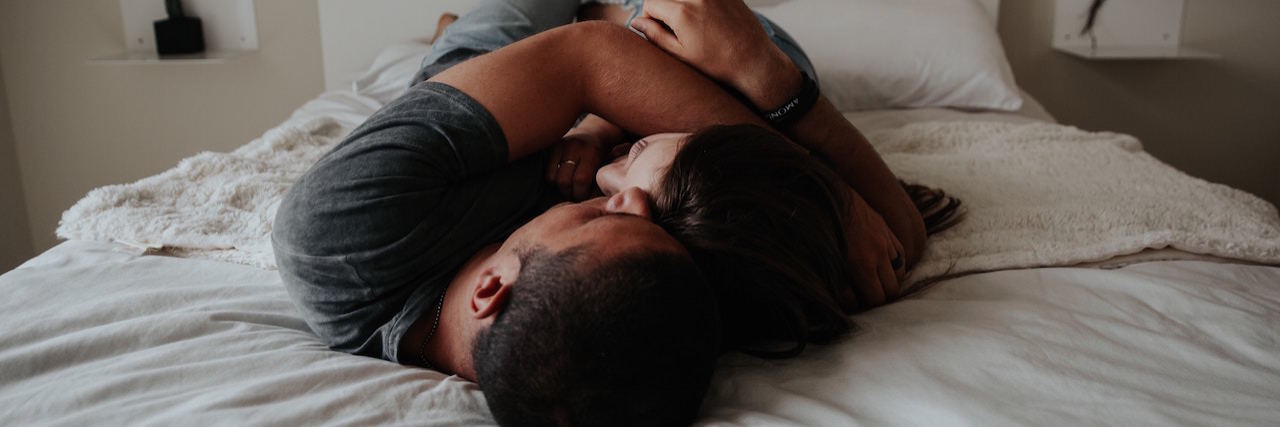 How to Support Your Girlfriend With Anxiety on Valentine's Day A man and a woman holding each other in bed