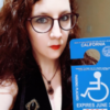 Amelia holding her disability parking placard.