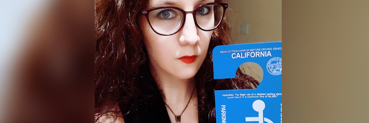 To the Police Officer Who Harassed Me About My Disability Parking Placard Amelia holding her disability parking placard.