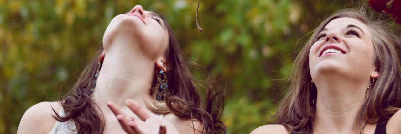 How Other Patients Help in Eating Disorder Treatment photo of two young women throwing autumn/fall leaves into the air and smiling