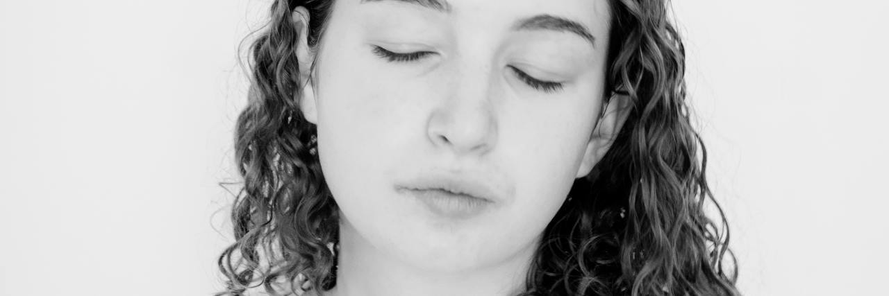 black and white photo of young woman with curly hair and eyes closed