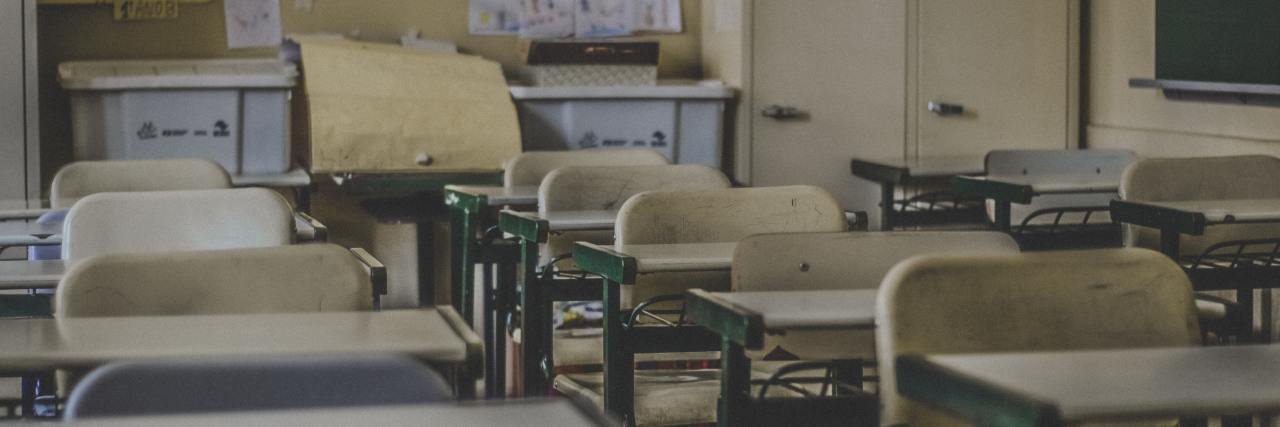 Therapy and Counseling Should Be Part of Everyone's School Education classroom lined with desks and a bulletin board in the back