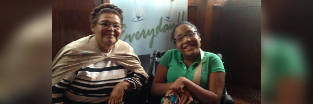 The writer sitting with her grandmother, both looking and smiling at the camera