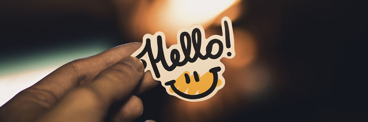 How Asking 'How Are You?' Casually Hurts People With Chronic Illness hello badge with smiley face