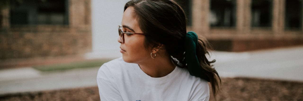 The Best Way I Found to Cope With the Loneliness of Being Misdiagnosed woman sitting on a brick wall