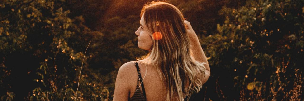 How Prednisone Weight Gain Affected My Eating Disorder photo of woman standing on hill at sunset looking out over distance