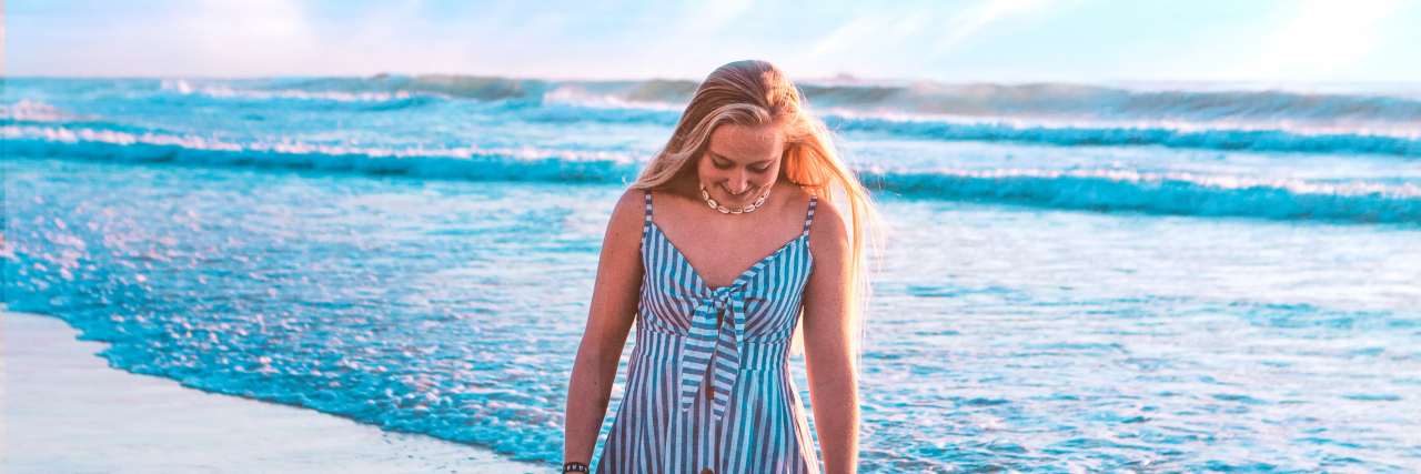 Depression, Anxiety and Learning to Be Alone photo of a woman in a dress walking along a beach
