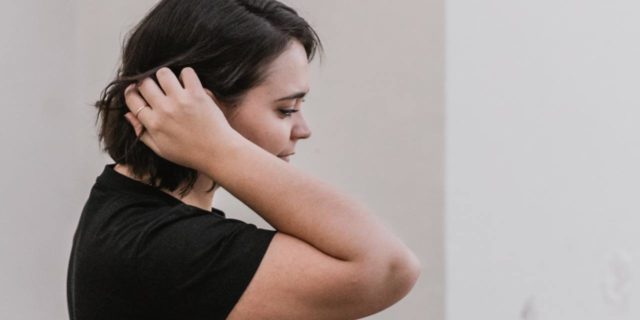 photo of plus-size woman with hand in her hair and eyes closed