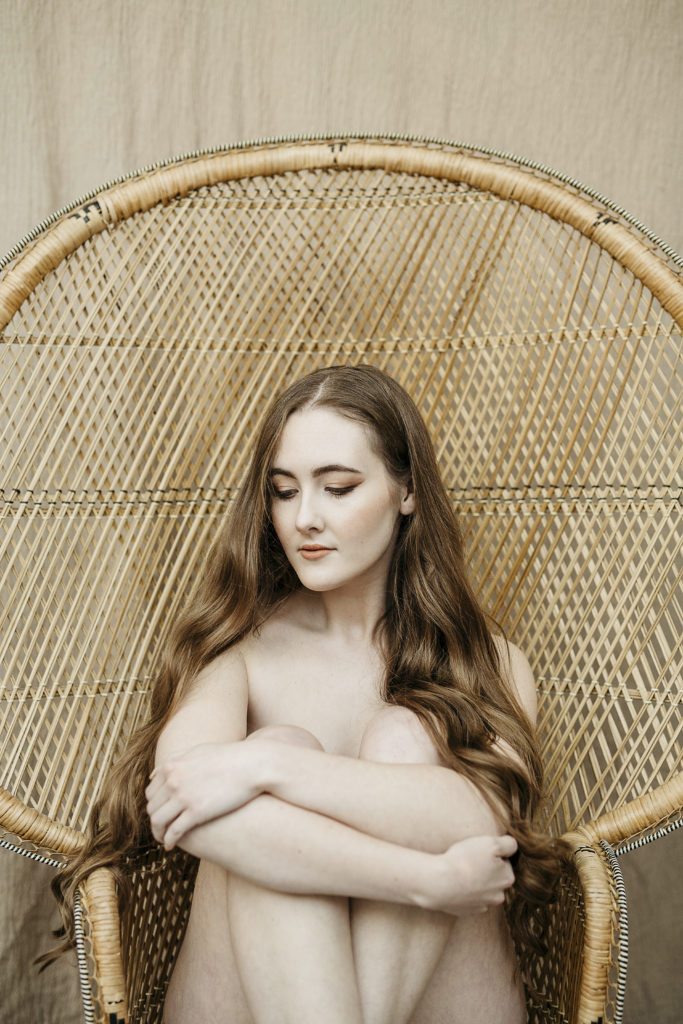 Georgina posing tastefully nude in a wicker chair.