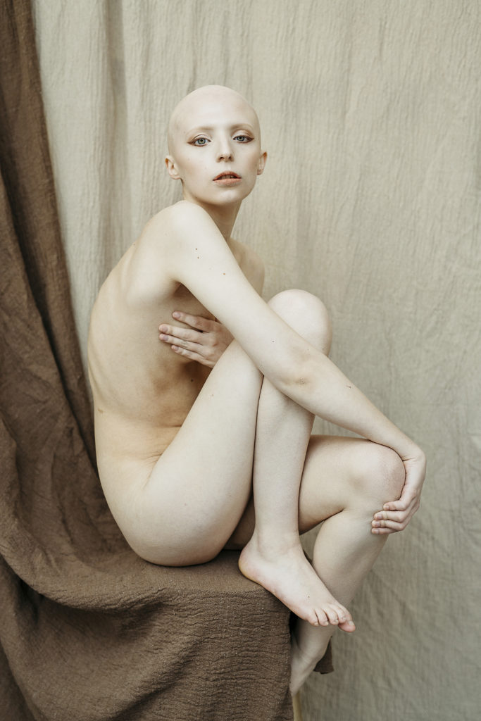 Niamh, a bald woman posing tastefully nude.